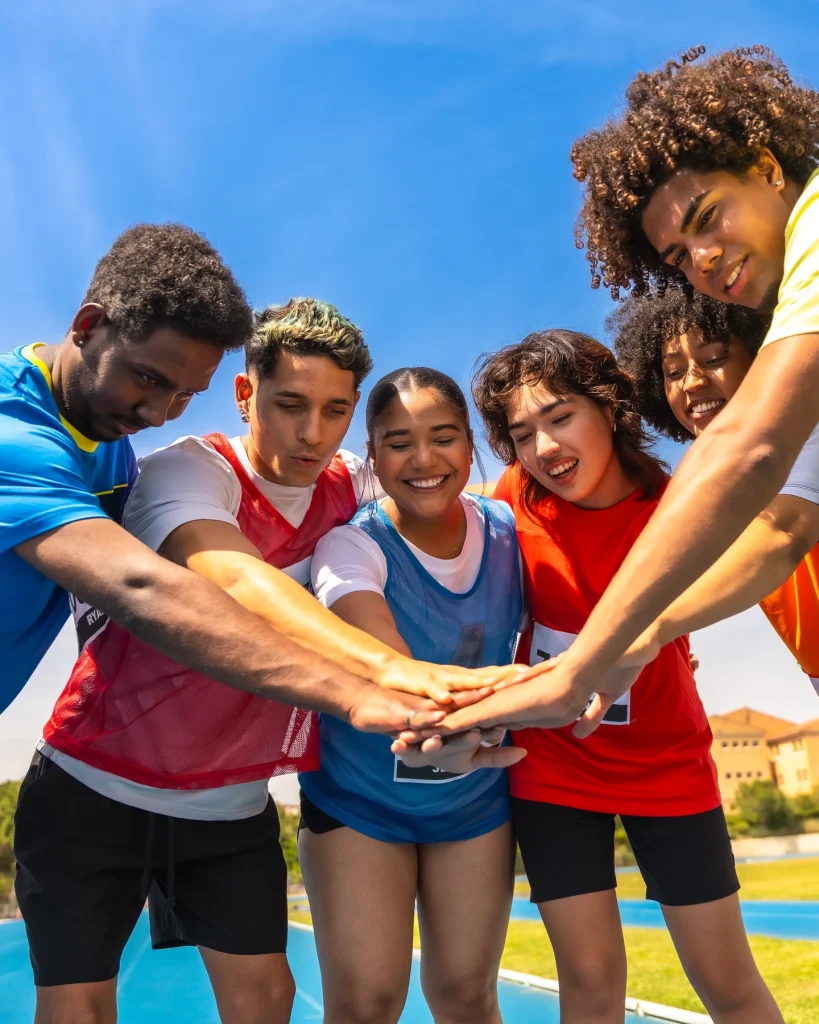 Jeunes sportifs réunissant leurs mains avant un jeu