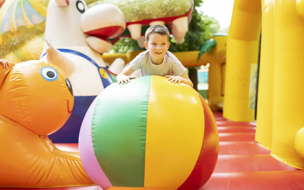 Enfant dans un château gonflable avec un ballon géant
